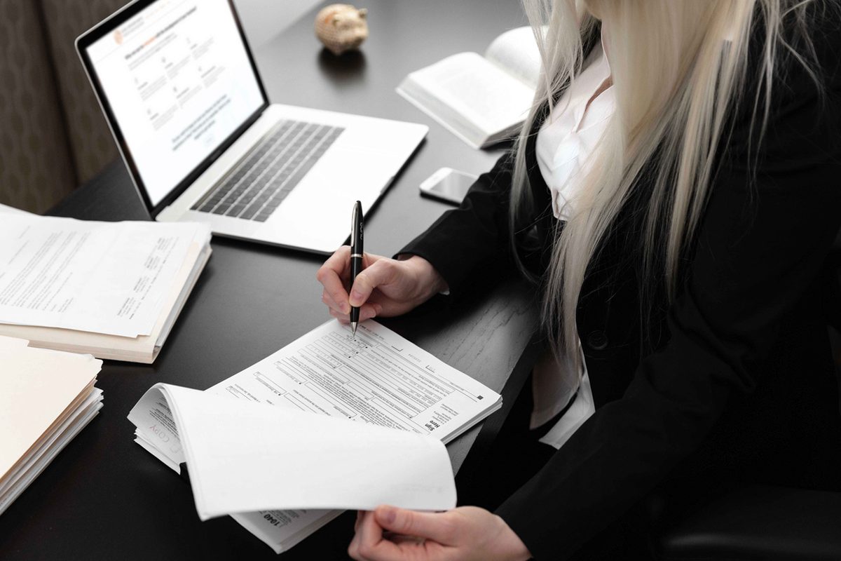Olga Grigoryants, CPA, signing a tax return at her desk